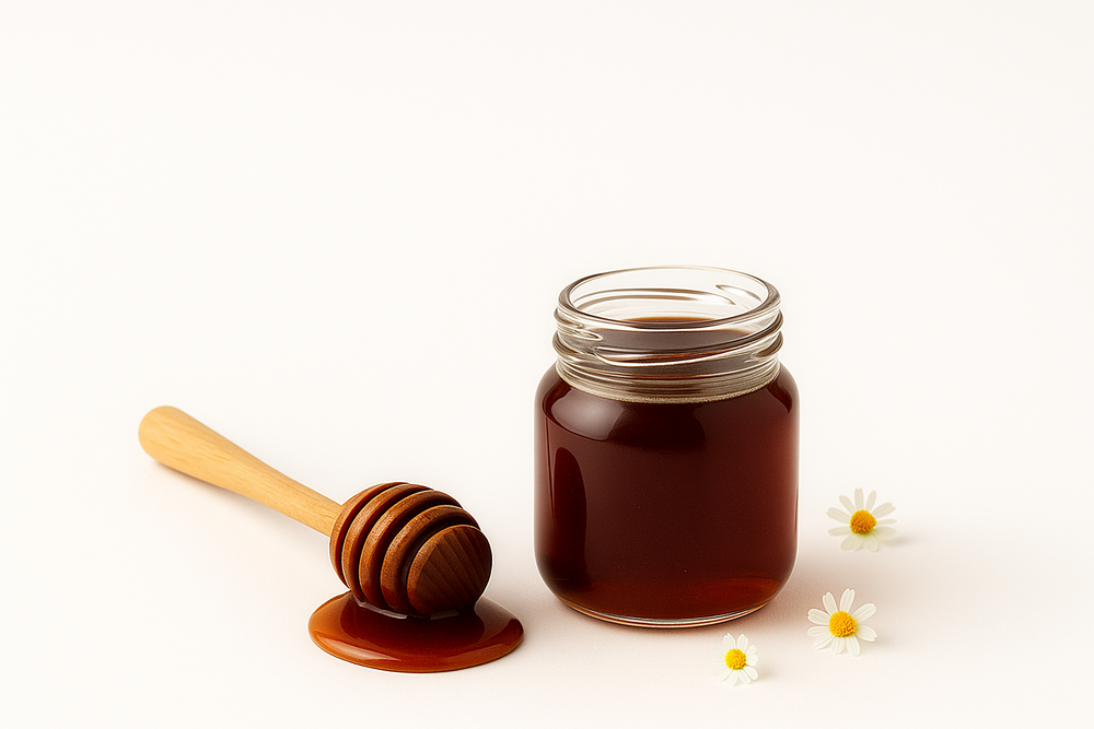 Toples madu dengan dipper kayu dan bunga daisy di latar putih