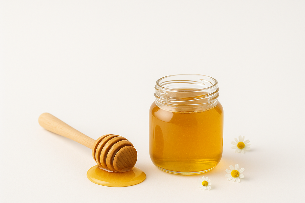 Toples madu dengan dipper kayu dan bunga daisy di latar putih